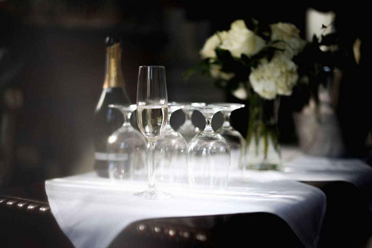 Side-by-side photo: cluttered backdrop vs. minimalist draped fabric with string lights for anniversary design