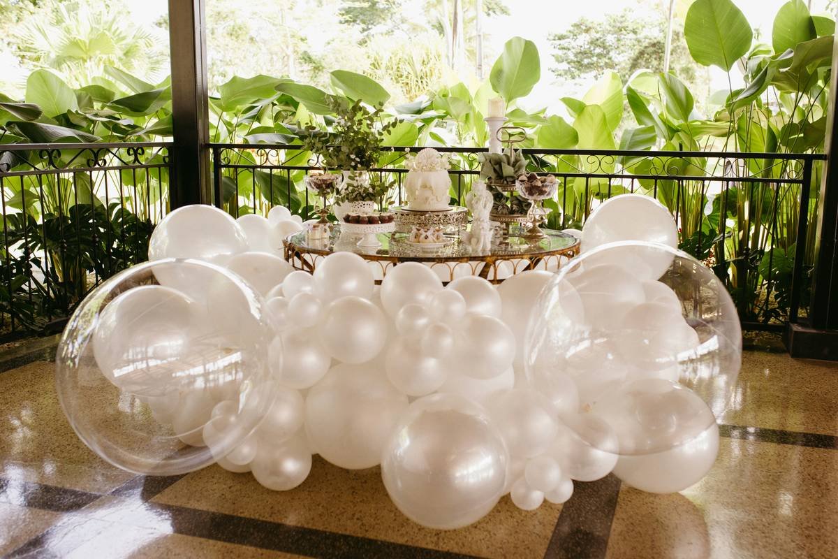 Elegant anniversary party decoration ideas featuring organic balloon garland and engraved place settings